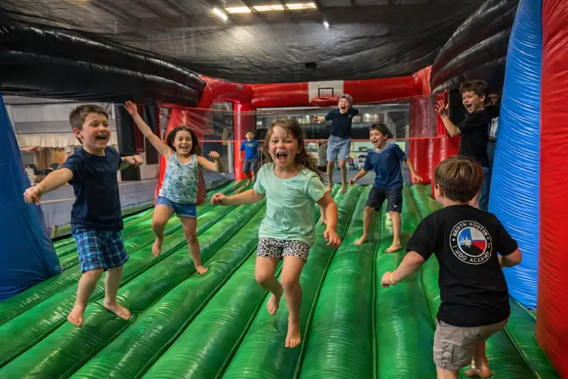 Children running inside the inflatable obstacle course at a kids birthday party in Waco TX