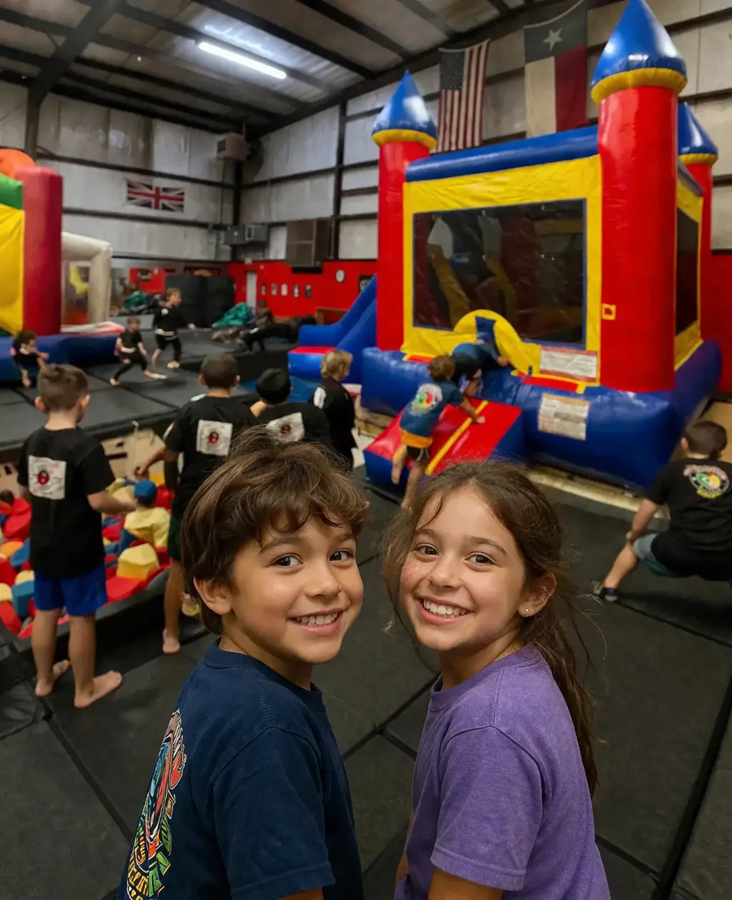 Two children smiling at a birthday party inside Bouncing Fun Factory in Waco, Texas
